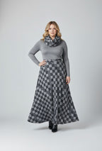 Woman wearing a gray sweater and checkered skirt on a white background