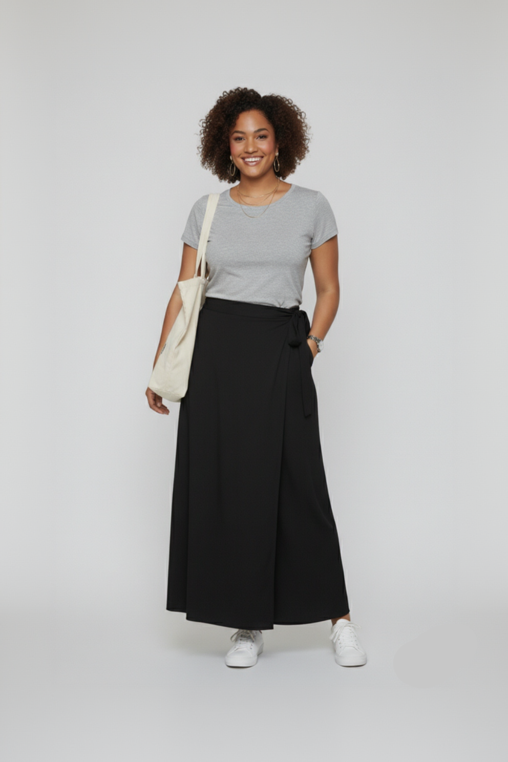 Woman wearing a gray t-shirt and black wrap skirt with a white background
