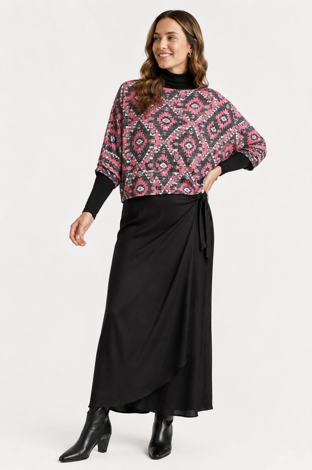 Woman wearing a patterned top and black skirt on a white background