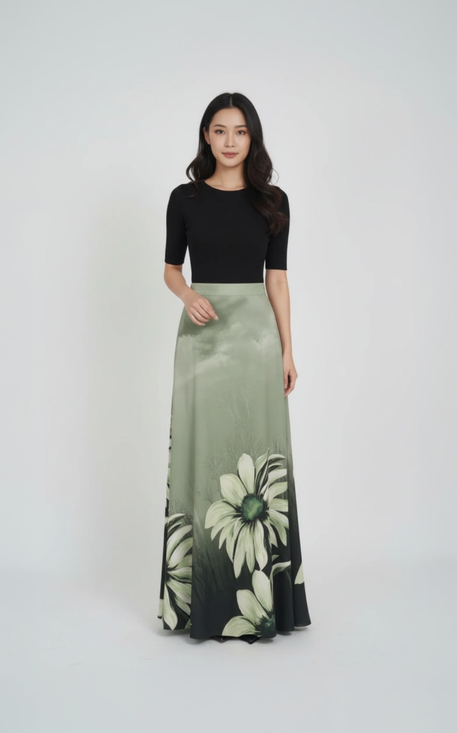 Woman wearing a black top and green floral skirt on a white background