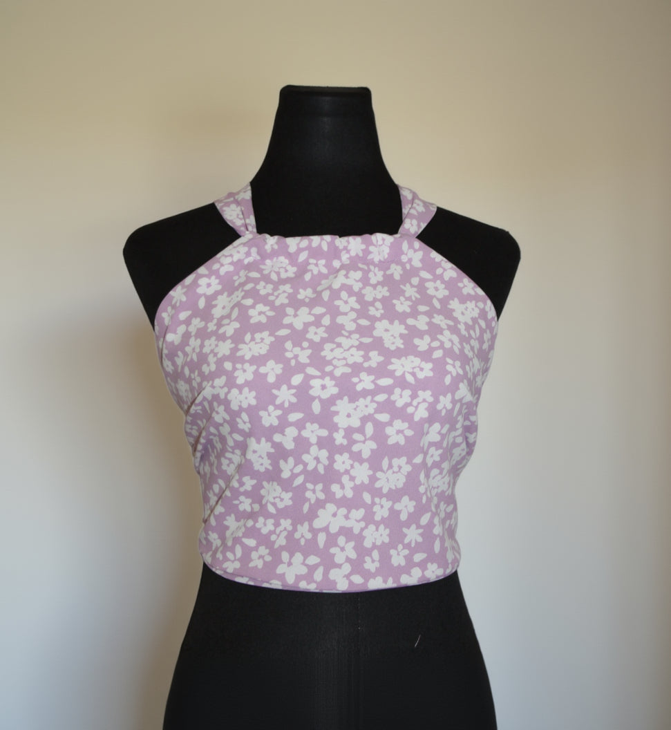 Purple floral-patterned top on a black mannequin against a white background