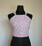 Purple floral-patterned top on a black mannequin against a white background