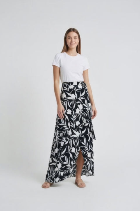 Woman wearing a white t-shirt and black and white floral maxi skirt on a white background