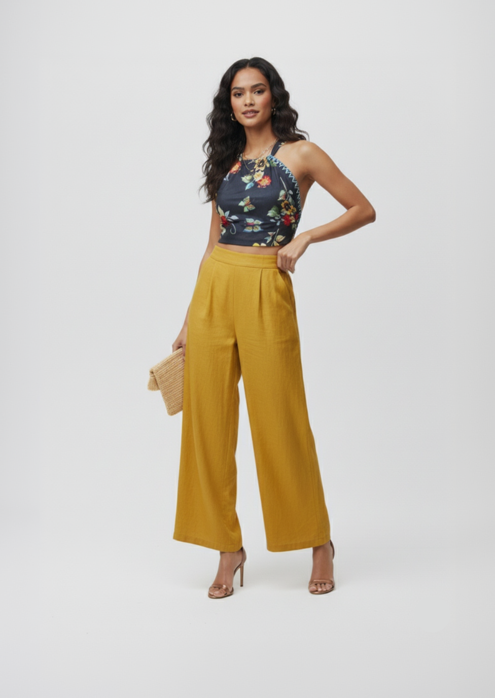 Woman wearing a floral top and yellow pants on a white background
