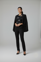 Woman wearing a black suit with a patterned top on a gray background