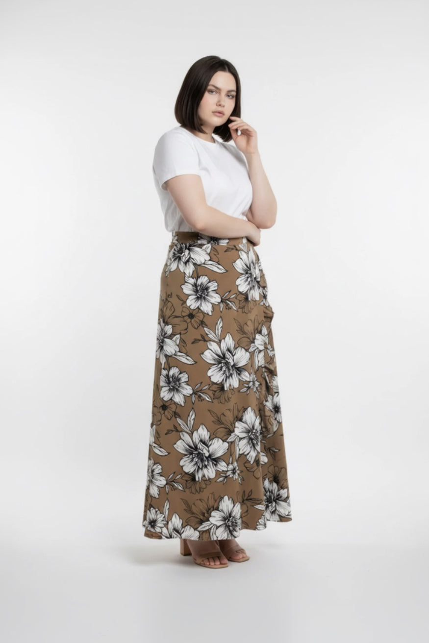 Woman wearing a white top and brown floral skirt on a white background