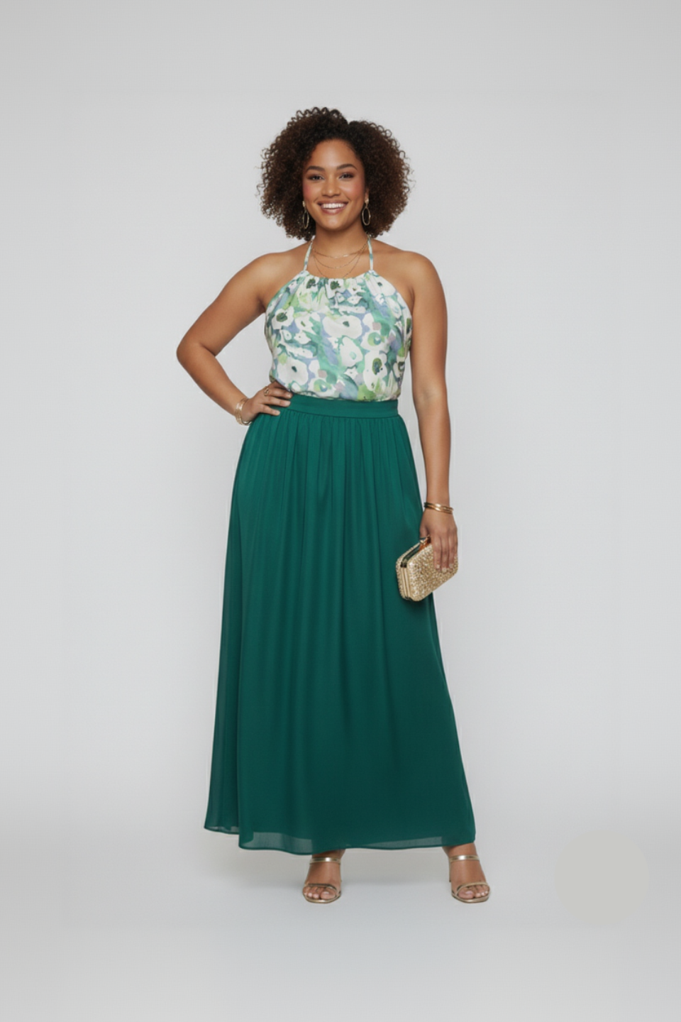 Woman wearing a floral top and green skirt with a white background
