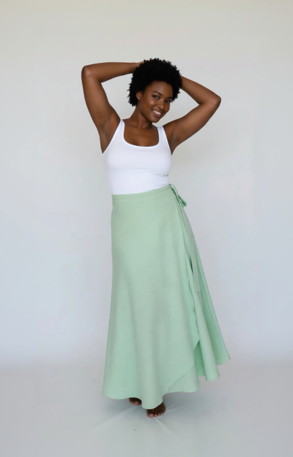 woman wearing a green polka dot skirt on a white background