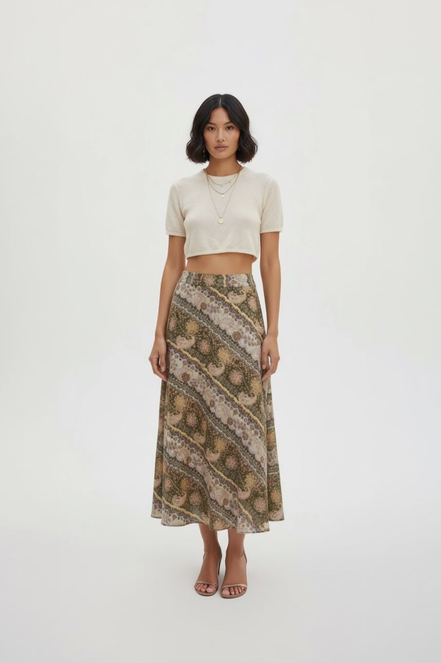 Woman wearing a patterned skirt and white top on a white background