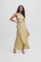 Woman wearing a yellow floral dress with a white background