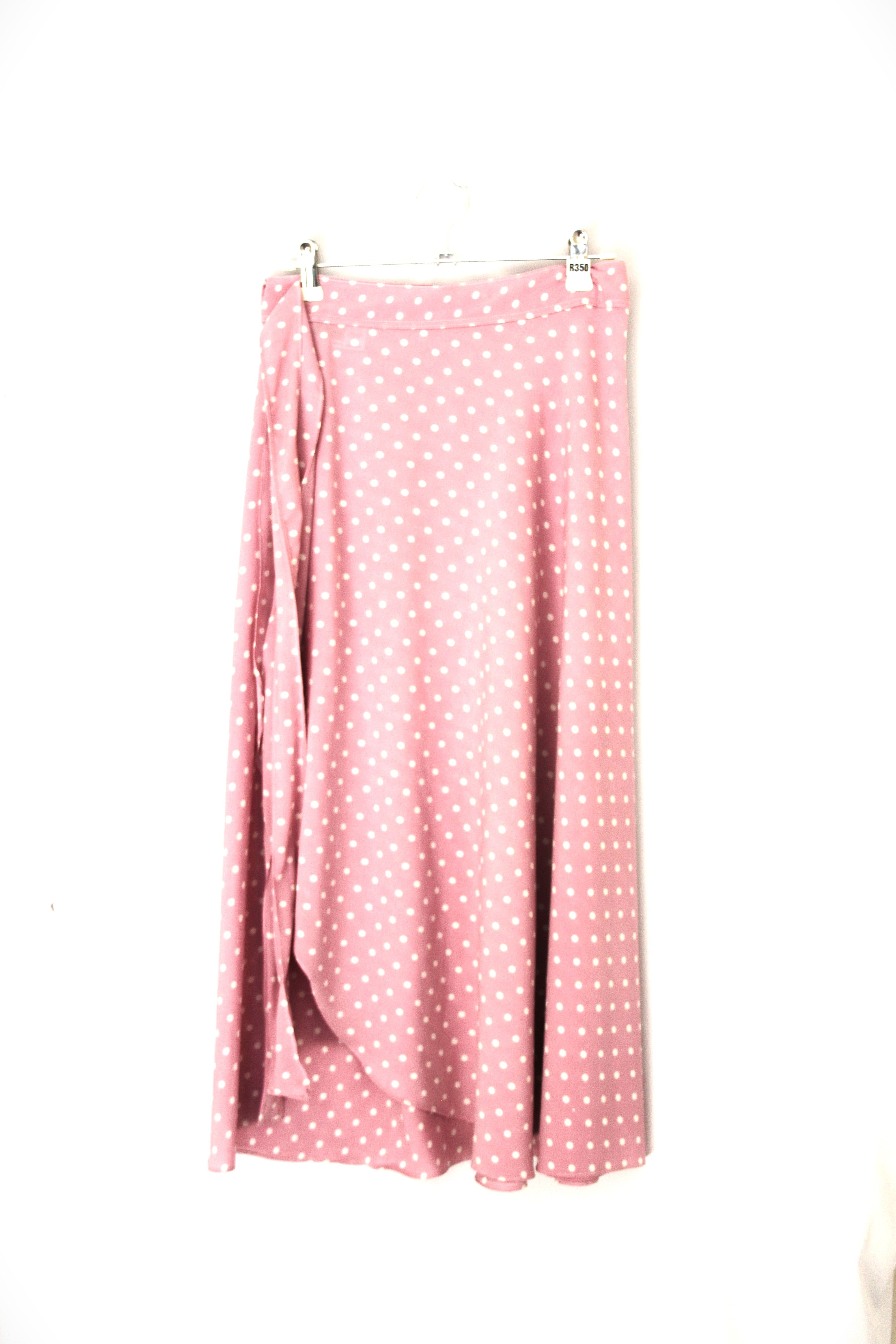 Pink polka dot fabric draped over a white background