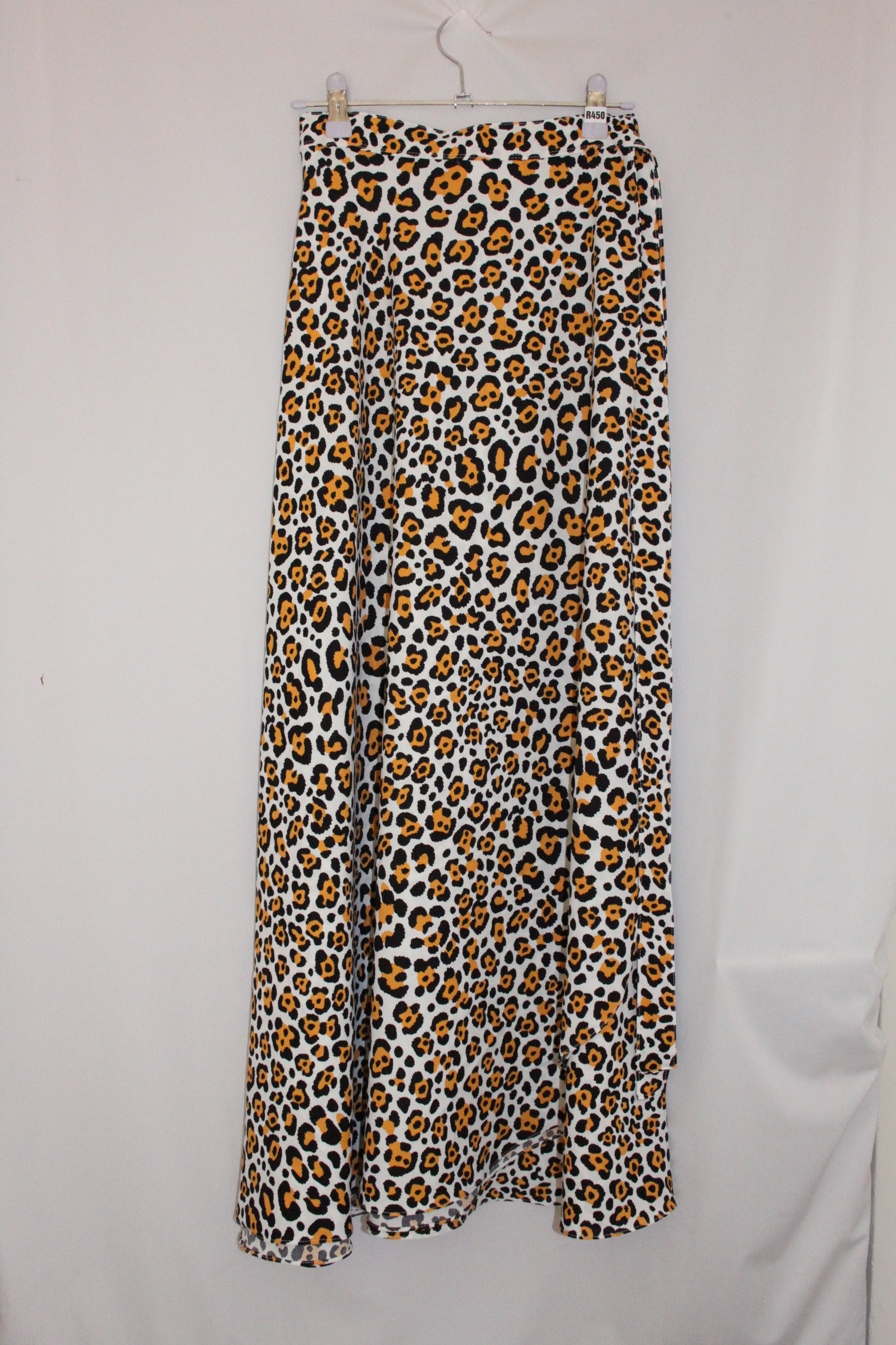 Leopard print skirt hanging on a white background