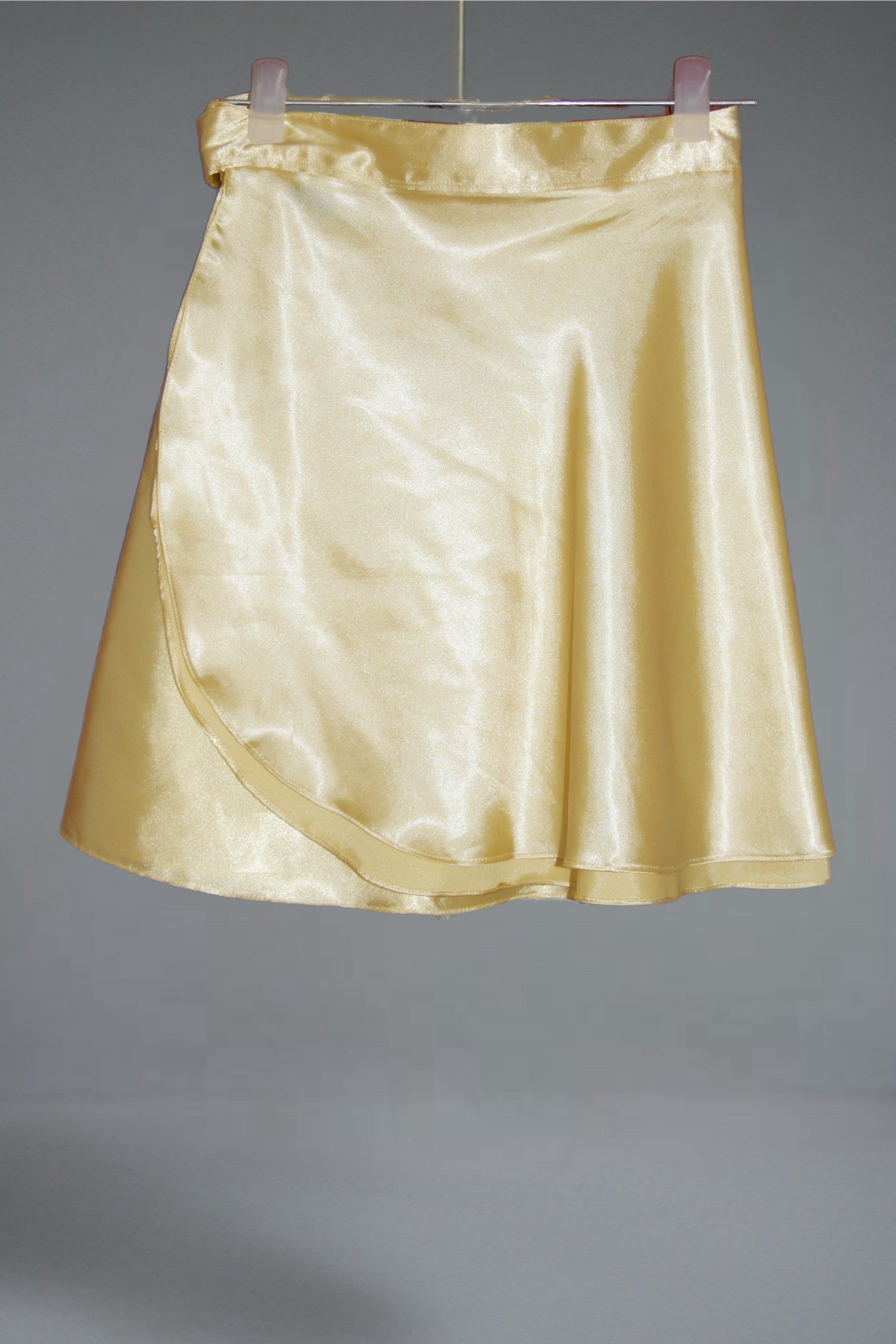 Gold satin skirt on a gray background